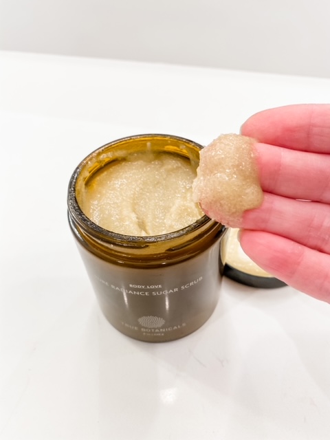 sugar scrub with scoop on fingers